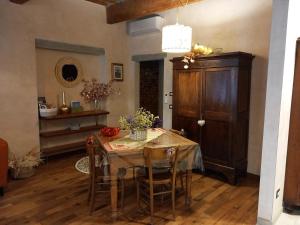 une salle à manger avec une table, des chaises et une armoire dans l'établissement Casa Clery, stile toscano, vicino a firenze, à Montelupo Fiorentino