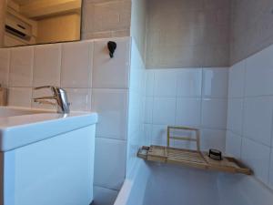 un baño con lavabo y una silla en un estante en Bulle ivoire en Hastière-par-delà