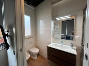een badkamer met een wastafel, een toilet en een spiegel bij Elisabeth Suite Apartment in Terracina