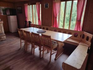 a dining room with a wooden table and chairs at Chata FORESTINA in Vyšné Ružbachy