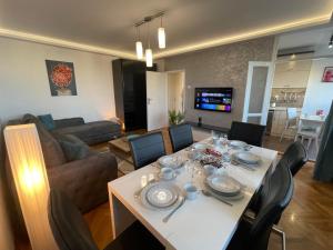 - une salle à manger et un salon avec une table et des chaises dans l'établissement Like home2, à Belgrade