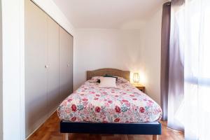 sypialnia z łóżkiem z narzutą kwiatową w obiekcie le bruit des vagues sur gîte echarou w mieście Port-la-Nouvelle