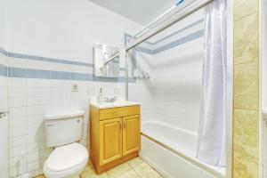 a bathroom with a toilet and a tub and a sink at The Stairway Suites - Convention Center in Philadelphia +11 photos