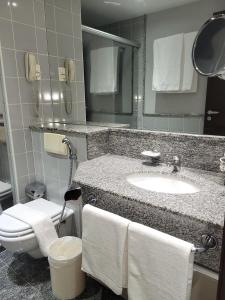 a bathroom with a sink and a toilet and a mirror at Flat Super Luxo Verbo Divino in Sao Paulo