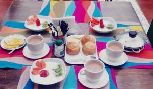 una mesa con platos de comida y tazas de café en Ayenda Colina Real en Pasto