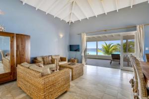 a living room with a couch and a table at Oceanfront - Villa Port of Call - in Kralendijk