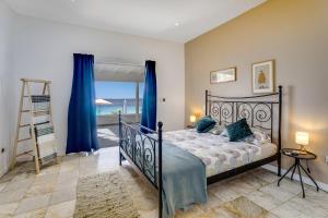 a bedroom with a bed with a view of the ocean at Oceanfront - Villa Port of Call - in Kralendijk