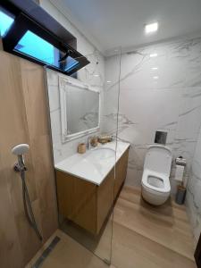 a bathroom with a white toilet and a sink at Guest House EGO in Bratsigovo