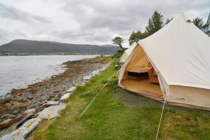 a large white tent on the side of a body of water at Sandtorgholmen Glamping in Sandtorg
