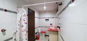 a white bathroom with a toilet and a shower at Hotel El Gran Chaparral in Calarcá +14 photos
