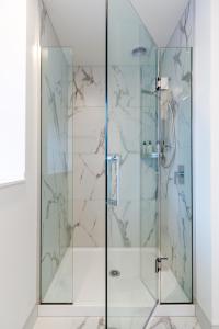 baño con ducha de cristal de mármol en Vibrant City Abode - 2 bed 2 bath, en Christchurch