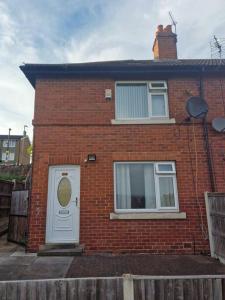 a brick house with a white door and windows at 3 bed house in Dewsbury West Yorkshire in Dewsbury