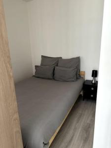 a bed in a white room with a bed frame at Studio JadOr gare du Bourget Paris aeroport Charles de Gaulle in Le Bourget