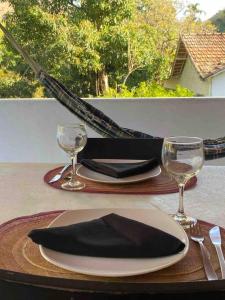 a table with a plate with a black napkin and glasses at Loft do Sítio São José in Petrópolis