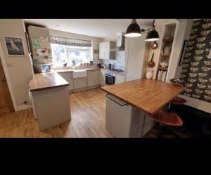 cocina con encimera de madera y mesa de madera en Lovely double bedroom house 1 en Buckinghamshire