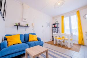 a living room with a blue couch and a table at Wellness Bubble - Cathédrale - Hypercentre in Reims