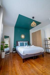 a bedroom with a large bed with a green wall at Wellness Bubble - Cathédrale - Hypercentre in Reims