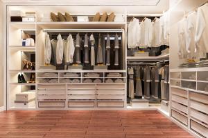 a walk in closet with white shelves and white cabinets at فندق العالمي ستار in Madīnat Zāyid