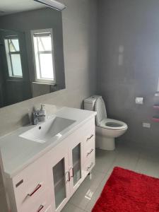 uma casa de banho com um lavatório branco e um WC. em HotelSuse em Napier