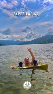 a child laying on a surfboard in the water at Cabaña Privada o Casa Privada Tana in Prado