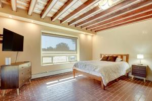 Un dormitorio con una cama y un televisor de pantalla plana. en Scenic Santa Fe Vacation Rental with Views and Hot Tub, en Santa Fe