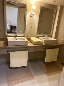 a bathroom with two sinks and two mirrors at Charming luxurious 2 bedroom apartment in zamalek in Cairo