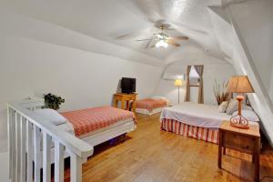 a bedroom with two beds and a ceiling fan at Olive Cabin in Fredericksburg