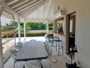 a patio with a table and chairs and a kitchen at Villa Livia in Le Marin