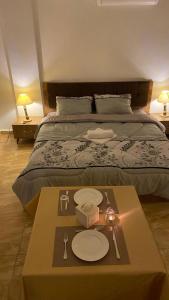 um quarto com uma cama com uma mesa com pratos em Petra Everest Hostel em ‘Ayn Amūn