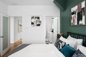 sypialnia z białym łóżkiem i zieloną ścianą w obiekcie Les Lofts du Mont Royal w Montrealu