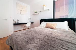 a bedroom with a large bed and a window at Prague Marina River View Apartment Close To City Centre FREE PARKING in Prague