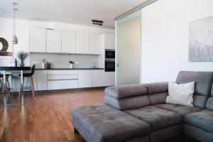 a living room with a couch and a kitchen at Prague Marina River View Apartment Close To City Centre FREE PARKING in Prague +9 photos
