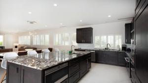 a kitchen with black cabinets and a counter top at Laguna Del Mar in George Town