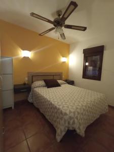 sypialnia z łóżkiem i wentylatorem sufitowym w obiekcie Casa rural Labrador a 9k de Monfragüe w mieście Torrejón el Rubio