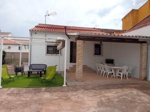 a patio with chairs and a table in a house at Casa rural Labrador a 9k de Monfragüe in Torrejón el Rubio