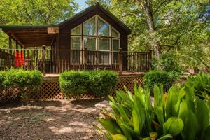 a house with a large deck in the woods at Fig Cabin in Fredericksburg