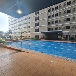 a swimming pool in front of a building at HOMELY @ Green 2 Residences SMDC DLSUMC in Dasmariñas