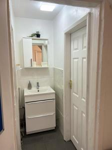 a white bathroom with a sink and a mirror at 4 BRH for Large Group Birmingham in Birmingham