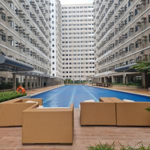 - un grand bâtiment avec une piscine en face dans l'établissement HOMELY @ Green 2 Residences SMDC DLSUMC, à Dasmariñas