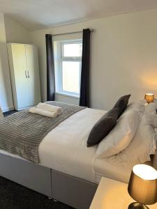 een slaapkamer met een groot bed met kussens erop bij 4 BRH for Large Group Birmingham in Birmingham
