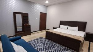 1 dormitorio con 1 cama y 1 sofá azul en Islamabad Layover Guest House Free Airport Pick and Drop en Islamabad