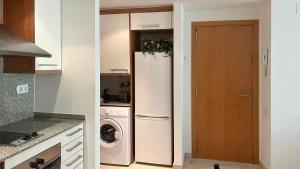 a kitchen with a refrigerator and a washing machine at Céntrico y con balcón in Terrassa