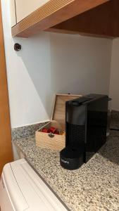 un aparato negro sentado en un mostrador junto a una caja en M1 Céntrico y con balcón, en Terrassa
