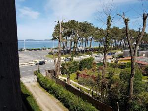 einen Balkon mit Blick auf eine Straße und das Meer in der Unterkunft Playa Samil Vigo Reformado 2016 in Vigo