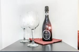 butelkę wina i dwa kieliszki wina na stole w obiekcie Red Ferrari House - City center w mieście Modena