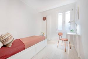 a white bedroom with a bed and a chair at Red Ferrari House - City center in Modena