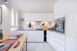 una cucina bianca con armadi bianchi e tavolo di Red Ferrari House - City center a Modena
