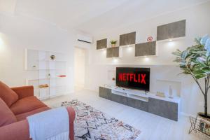 un soggiorno con TV e divano di Red Ferrari House - City center a Modena