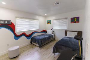 1 dormitorio con 2 camas y un cuadro en la pared en CryptoCabana, en Miami