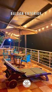 a deck with a table and chairs and an umbrella at Cabaña Privada o Casa Privada Tana in Prado